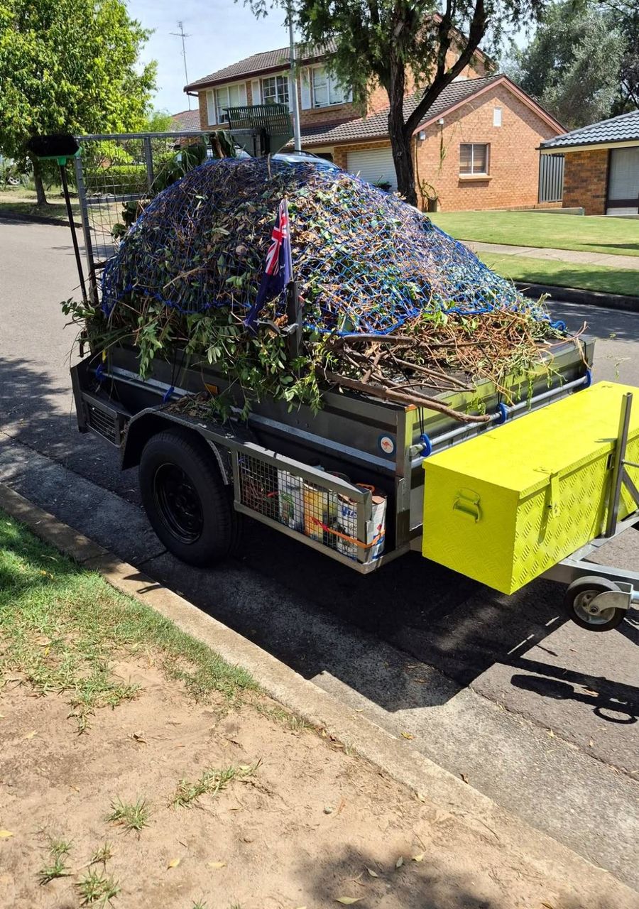Green With Envy trailer loaded with green waste under a cargo net after a Baulkham Hills yard cleanup